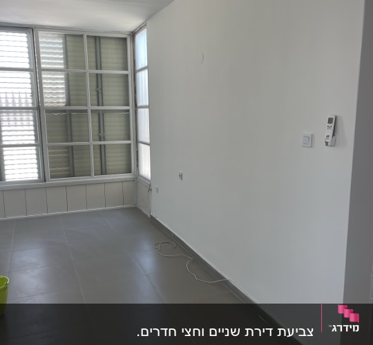 חדר עם קירות צבועים, רצפה חדשה ודלי ירוק
